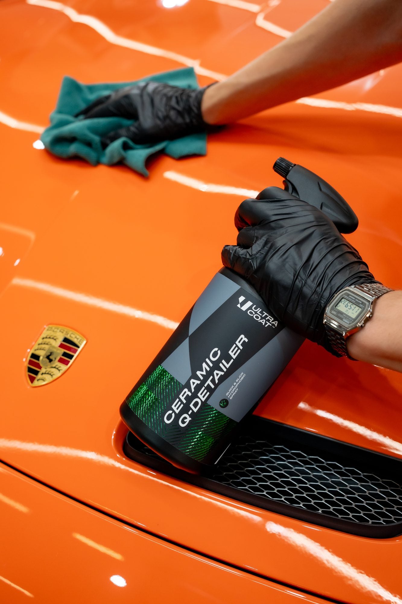 Ultracoat Ceramic Q-Detailer applied to orange Porsche paintwork beside the Porsche badge