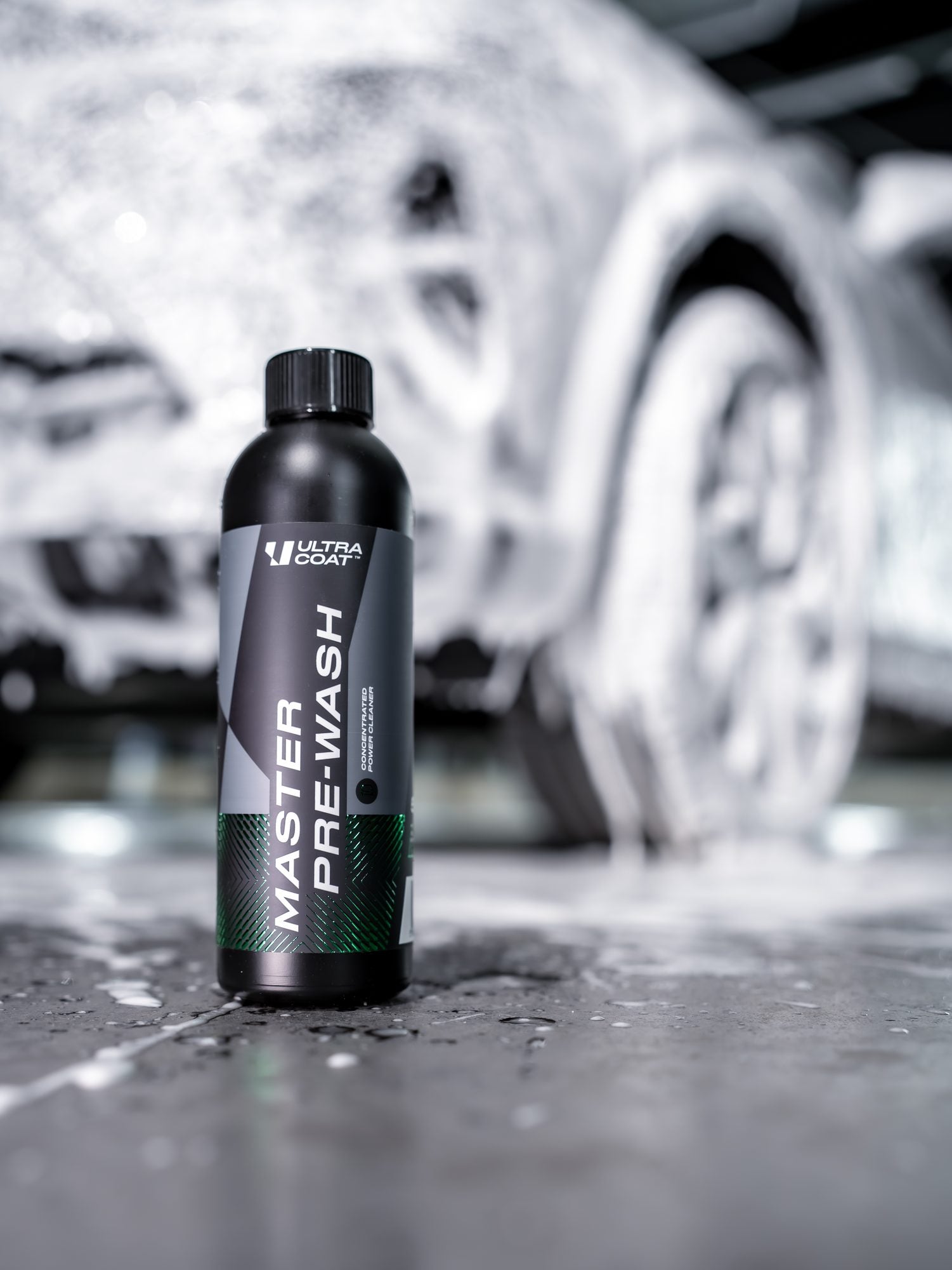 Ultracoat Master Pre-Wash bottle in front of a foamed vehicle