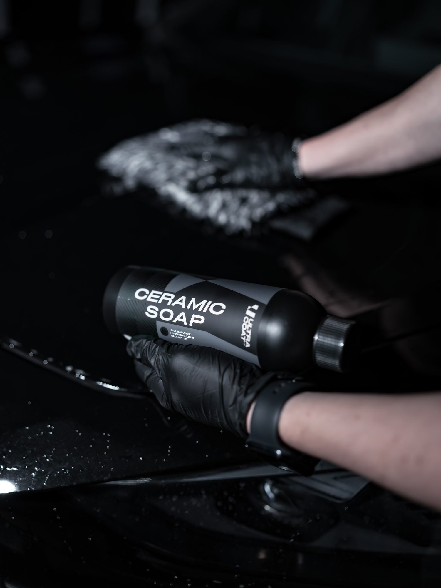 Ultracoat Ceramic Soap bottle held during the wash of a black vehicle