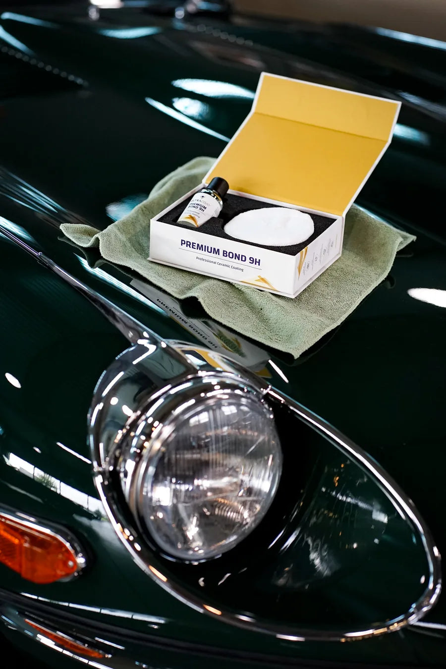 Ultracoat Premium Bond 9H ceramic coating packaging beside a classic car's chrome headlight